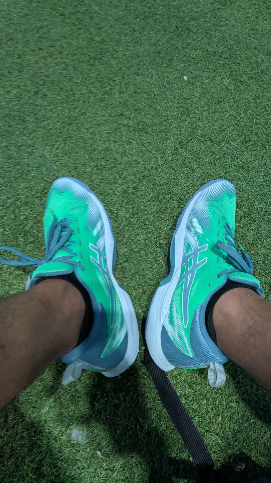 Asics Sonicsmash FF portées sur un terrain de padel en moquette indoor